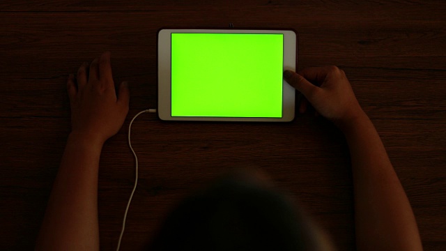 女人看绿色屏幕的平板电脑视频素材