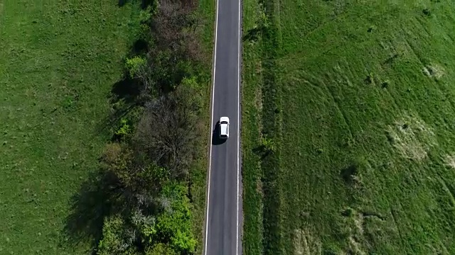 4K交通鳥瞰圖白色汽車行駛在鄉村道路上視頻素材