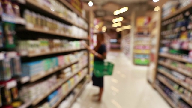 年轻的亚洲女人在杂货店购物，慢镜头视频素材