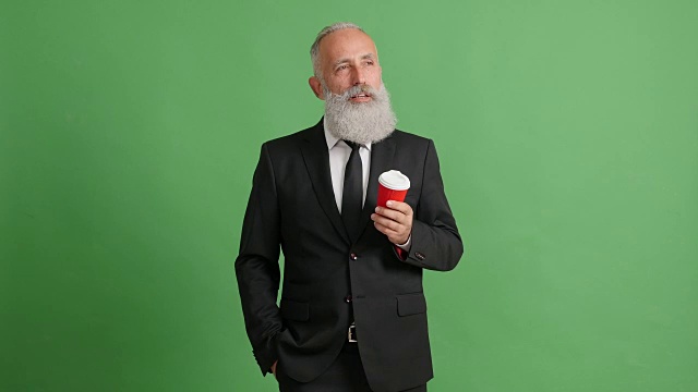 长着胡子的成年商人在绿色屏幕上喝咖啡视频素材