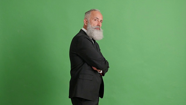 长着胡子的成年商人双臂交叉站在绿色屏幕上视频素材