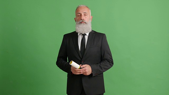 长着胡子的成年商人在绿色屏幕上按顺序领着一套西装视频下载