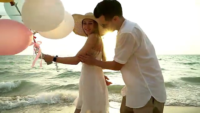 一对情侣在海滩上散步。年轻幸福的跨种族情侣走在海滩上微笑着彼此拥抱。亚洲女人，白人男人。视频下载