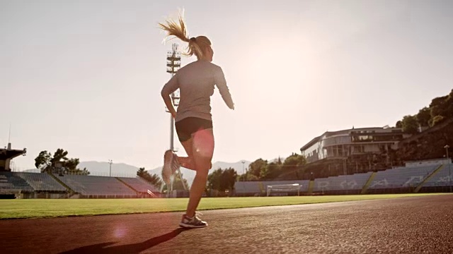 SLO MO DS女运动员在阳光体育馆跑步视频下载