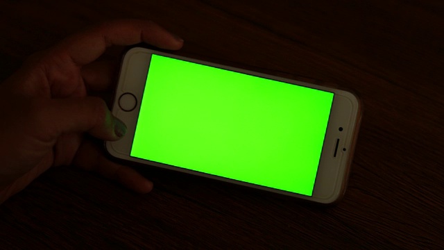 女人在看绿色屏幕的智能手机视频素材