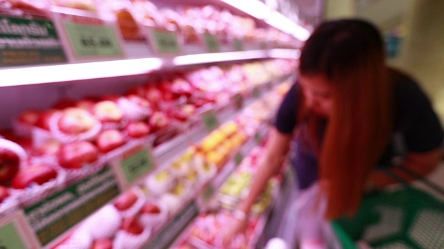 年轻的亚洲女人在杂货店购物，慢镜头视频素材