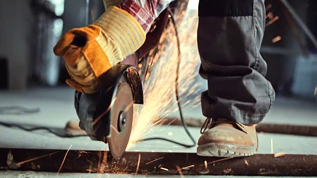 在施工现场，角磨机正被用来切割地面上的一根金属管视频素材