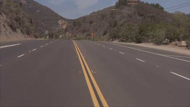 鏡頭拍攝在四車道公路上行駛。視頻素材