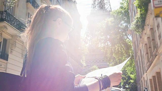 游客拿着巴黎地图，站在一条小巷里看埃菲尔铁塔视频素材