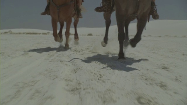 两个罗马士兵骑着他们的马穿过一片白雪皑皑的沙漠。视频素材