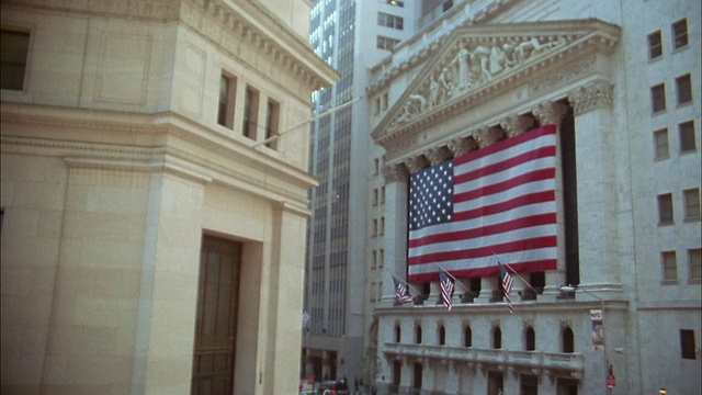 近距离观察在纽约证券交易所附近看报纸的商人，他们带着美国国旗视频下载