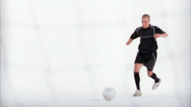 慢镜头远射足球运动员将球踢过假扑球的守门员视频下载