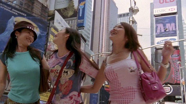 低角度中拍摄的三个女人拥抱和大笑在时代广场/纽约视频下载