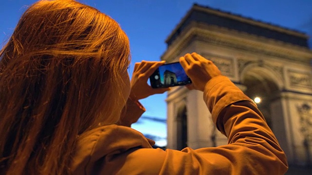 游客晚上用手机拍摄凯旋门视频素材