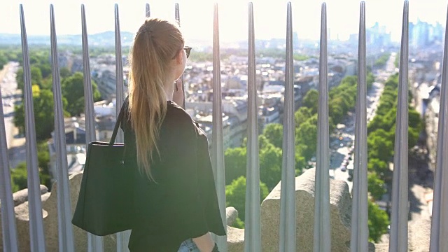 巴黎凯旋门上的一个女人指着远处的什么东西视频素材