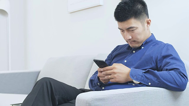 年轻的亚洲男子使用手机视频下载