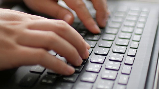 女人的手在笔记本电脑键盘上打字的特写视频下载