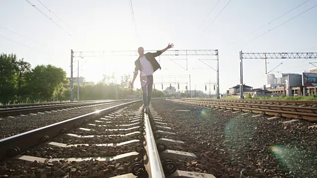 在铁路上行走的年轻人。摇滚风格。视频素材