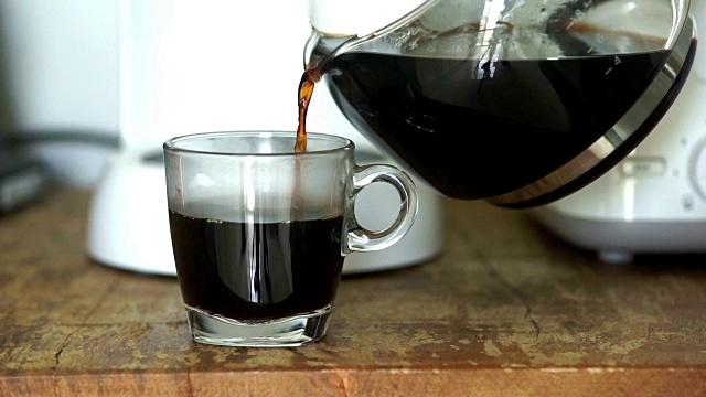 食物电影图片:早上在家里从玻璃壶里倒一杯热咖啡。视频素材