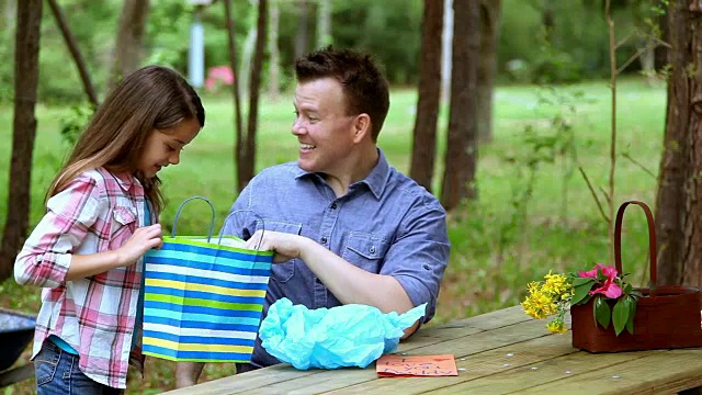 爸爸、女儿在户外带着父亲节或生日礼物。视频下载