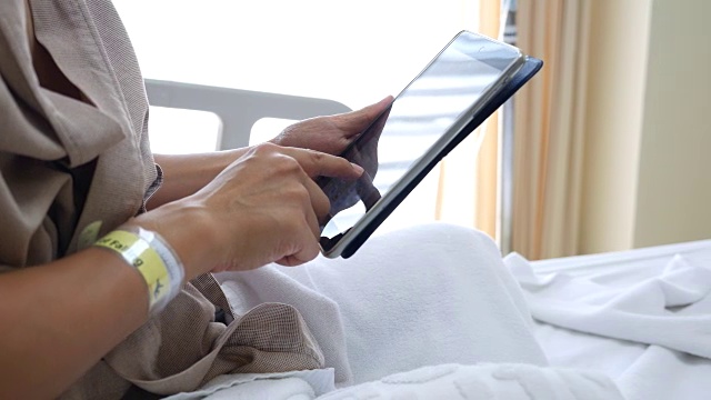 患者在床上使用数字平板电脑视频通话视频素材