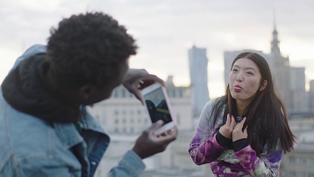 一名亚洲女性在屋顶上用智能手机拍照视频素材