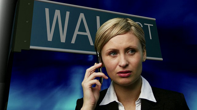 CU，复合，女商人正在用手机交谈，背景是华尔街的标志视频素材