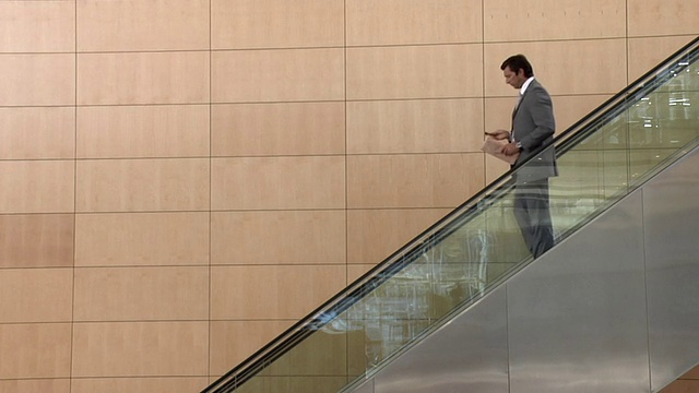南非開普敦，商人正從自動扶梯上下來，打著手機視頻下載