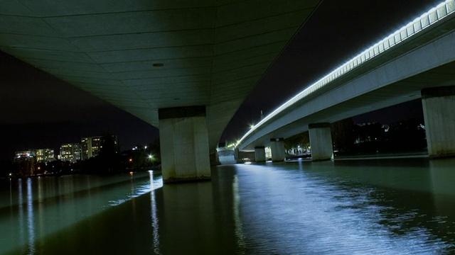 WS T/L PAN在澳大利亚首都地区堪培拉看到的桥梁和高速公路地下通道，夜间灯光在水中反射视频素材
