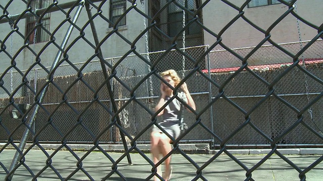 美国纽约，一名女子在学校操场上荡秋千时打电话视频素材