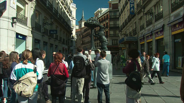 西班牙马德里太阳门，游客们在看熊和草莓树雕像视频素材