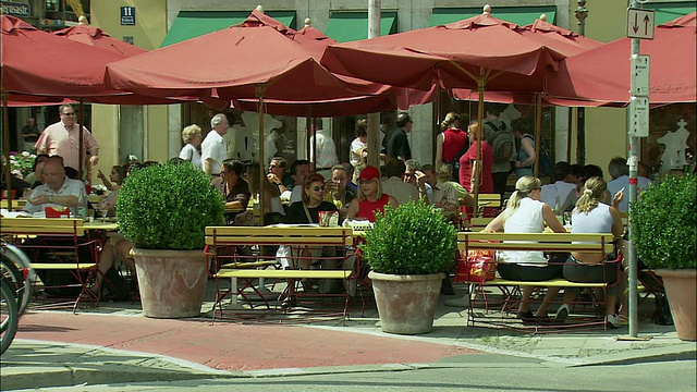 德国巴伐利亚州慕尼黑，骑自行车的女人，背景是户外咖啡馆视频下载