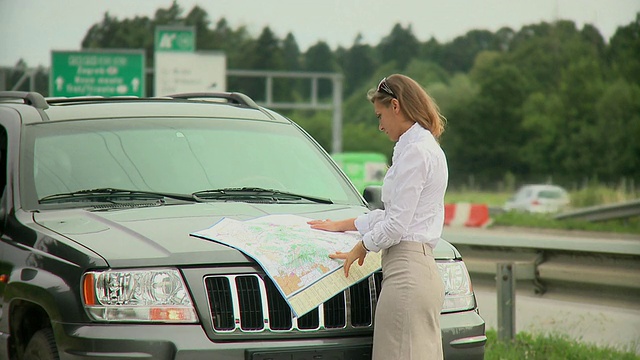斯洛文尼亚卢布尔雅那高速公路旁的一名年轻女子正在看公路地图视频素材
