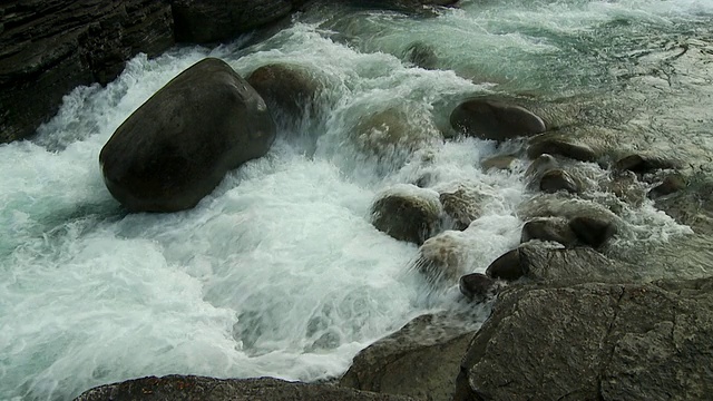 加拿大阿尔伯塔省，米斯塔亚峡谷/班夫国家公园，水流过光滑的巨石。视频素材