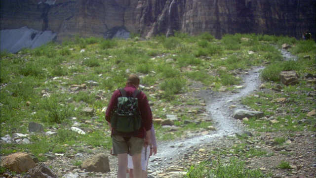 CU ZO WS徒步旅行者的后视图，在岩石小径上走向山与雪片/冰川国家公园，蒙大拿州，美国视频素材