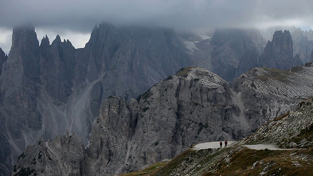 两名徒步旅行者的后视图，卡迪尼迪米苏里纳山脉覆盖着云的背景/上阿迪杰，意大利视频素材