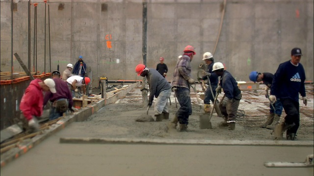 纽约市布莱恩特公园建筑工地的建筑工人正在铲湿水泥视频素材