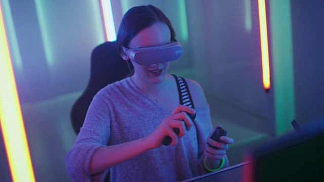 美丽的职业玩家女孩戴着虚拟现实耳机玩在线视频游戏，用控制器做手势。房间里的复古霓虹色很酷。视频下载