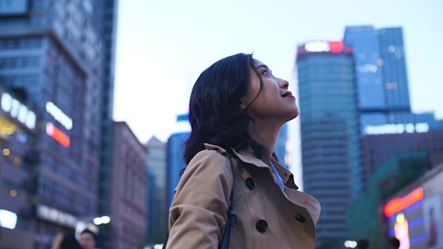 美麗的中國女人仰望城市的慢鏡頭視頻素材