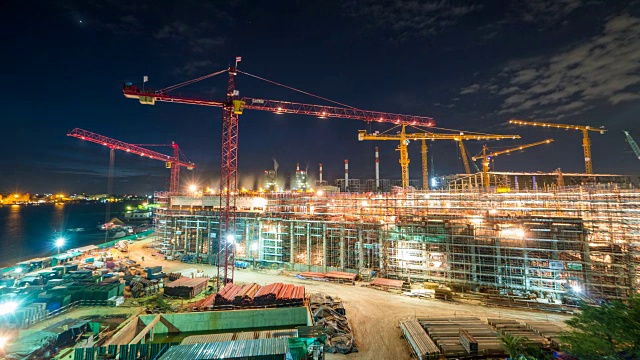 建筑工地和发电厂与塔吊在建筑工地和工人从黄昏到夜晚的时间流逝视频素材