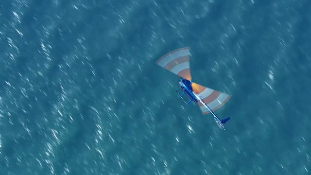 在阳光下，直升机正飞过海面视频素材