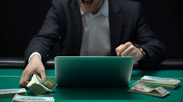 美元出现在赌场的桌子上，快乐的在线游戏赢家亲吻钱视频下载