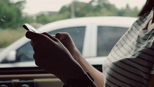 坐在车后座上用信用卡打电话的亚洲女人视频购买