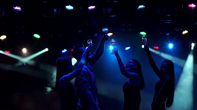 一群在迪斯科舞厅跳舞的青少年剪影。视频下载