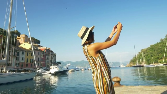 在欧洲的一个豪华度假小镇，一名女子一边自拍一边视频通话。——慢动作视频下载