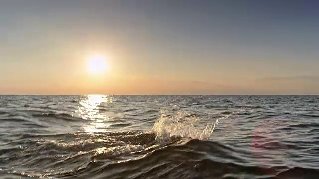 日落时分，一名男子在波涛汹涌的海面上游泳视频下载