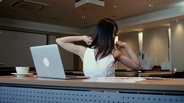在工作年龄的漂亮女人，会成为办公室综合症，她在她的办公桌伸展身体。视频下载