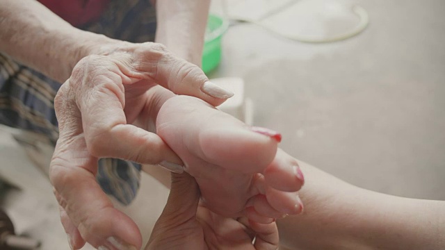 资深亚洲妇女有脚痛手指关节，痛风视频素材