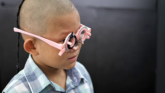 视力检查。有视力障碍的亚洲男孩。左眼在脑部手术中是看不见的。医疗和康复。视频4 k视频素材