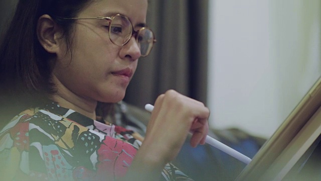 年轻的亚洲女性专业设计师在创意办公室使用图形平板电脑视频素材